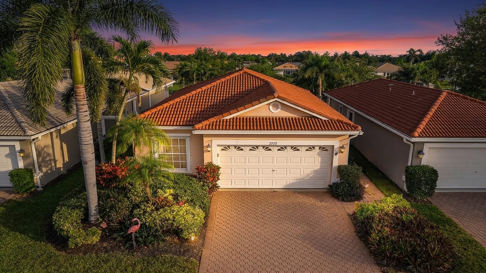 A single-story home at twilight with a glowing sunset sky, warm lights, and lush landscaping — an edited real-estate listing photo.