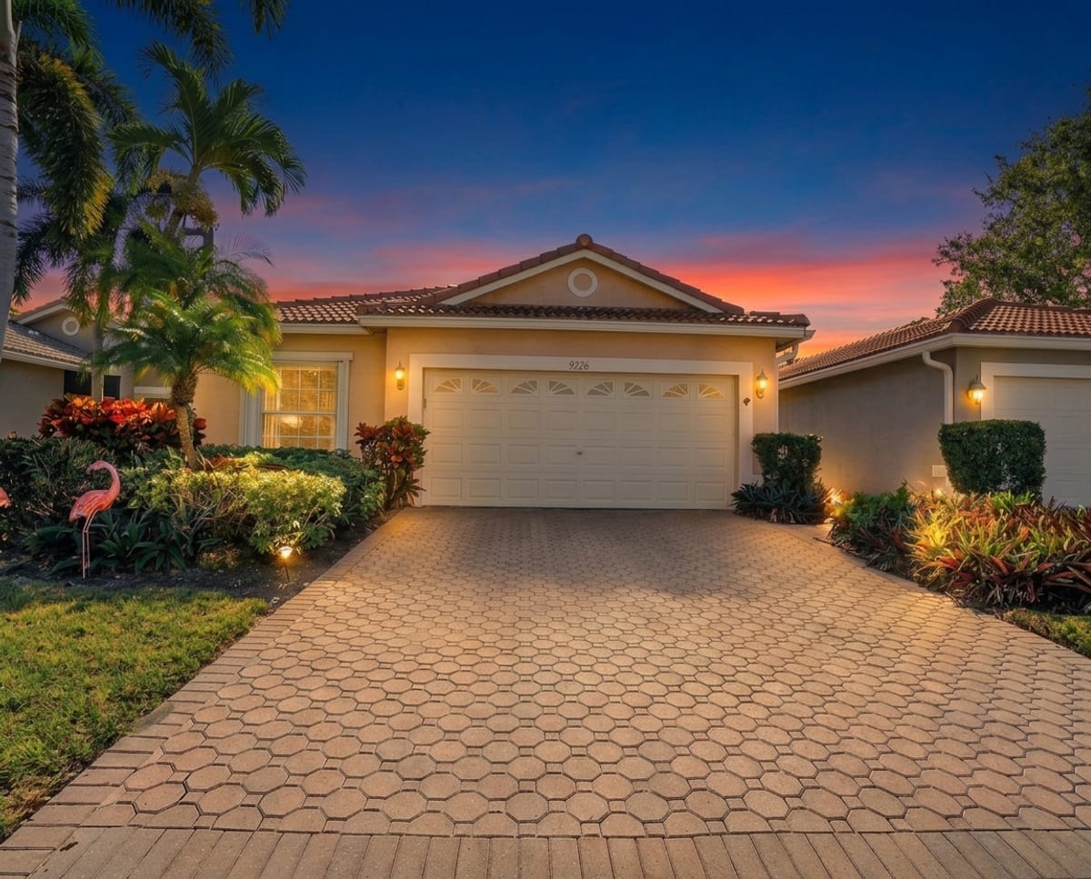 The same home at dusk with a warm sunset sky and glowing windows.